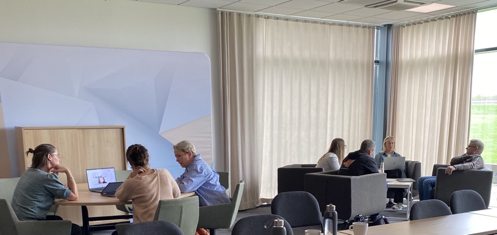 Anställda på AJ produkter sitter vid runda bord