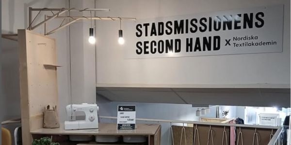 bild på en symaskin intill en skylt med Stadsmissionens och Nordiska Textilakademins logotype