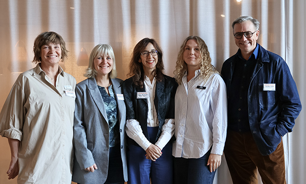 Gruppbild, helbild på fem personer som står upp och tittar in i kameran