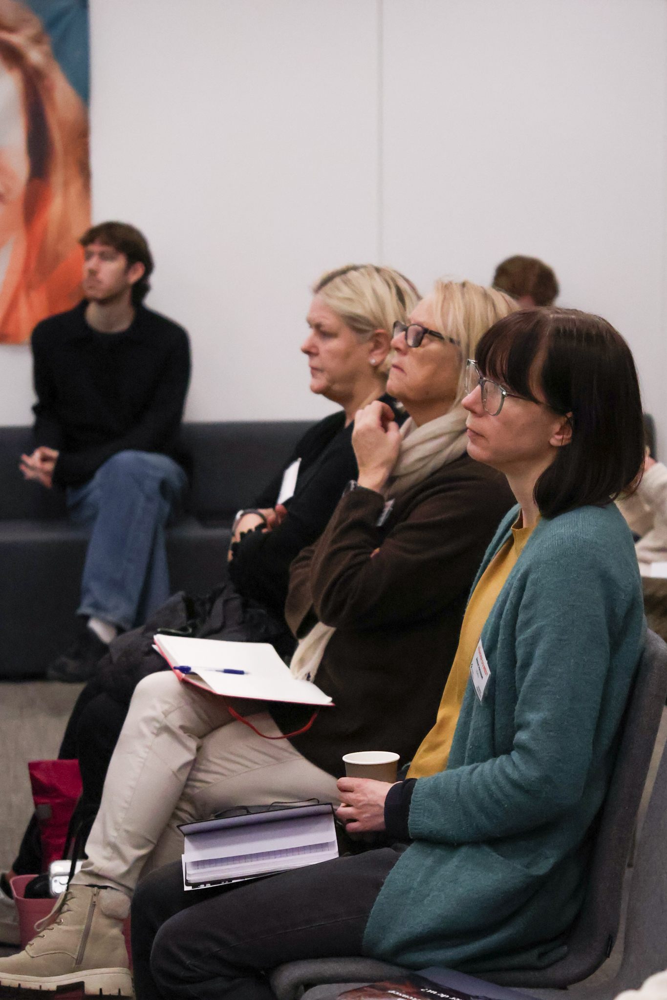 människor i publik sitter och lyssnar på talare