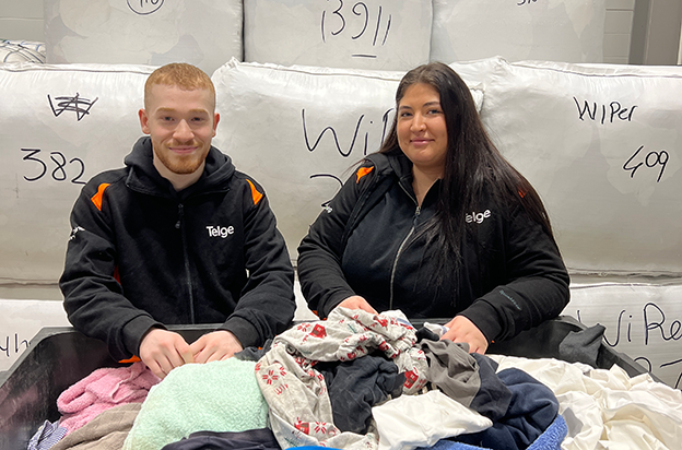 Två personer vid en korg med kläder