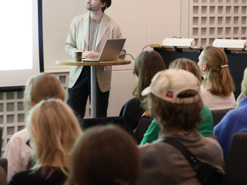 Bild på manlig talare framför publik