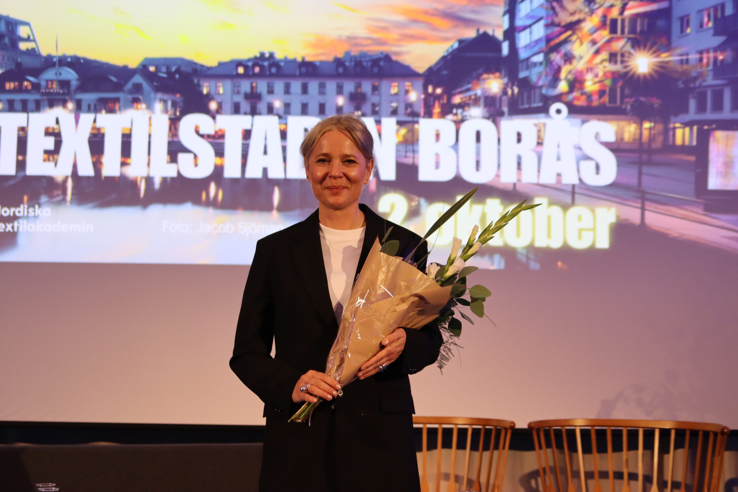 Kajsa Åström på scen med blommor i famnen